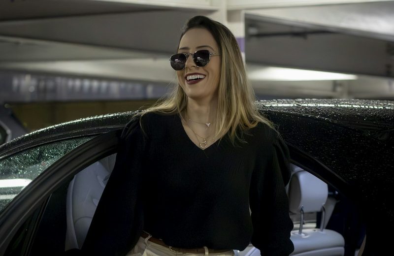 A passenger stepping out of a private transfer car at her destination